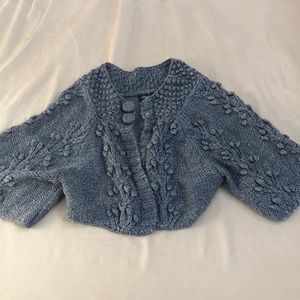Gray knitted shrug with tons of detail.